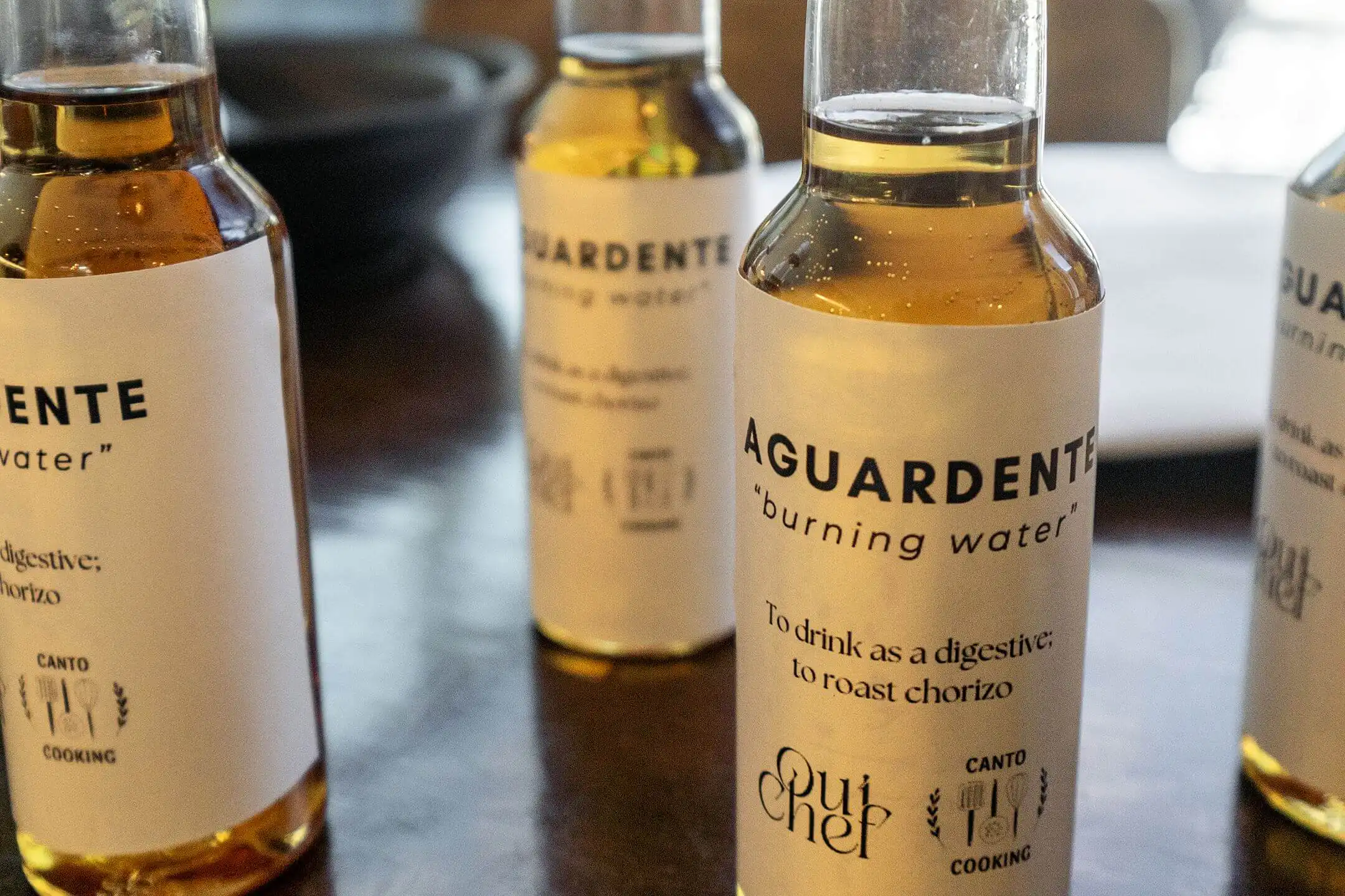 Bottles of Canto Cooking branded aguardente on a kitchen table in Porto