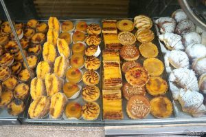Assorted traditional Portuguese pastries displayed in a bakery case