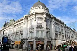 Ornate Belle Époque corner building with domed cupola on a busy Porto street