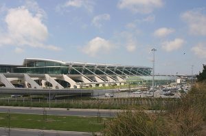 Exterior view of a modern airport terminal with a sweeping curved roof