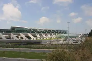 Exterior of a modern airport terminal with a curved roof and glass facade