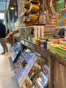 Bunte portugiesische Fischkonserven und Souvenir-Dosen, ausgestellt auf hölzernen Marktregalen