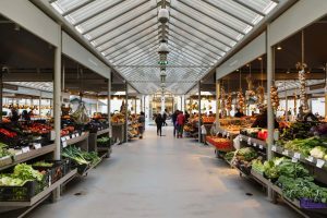 Interior of Bolhão Market with fresh produce stalls lining a glass-roofed hall