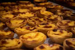 Freshly baked pastéis de nata arranged on a baking tray