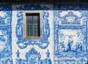 Blue and white azulejo tile facade of a Porto church with a stone-framed window