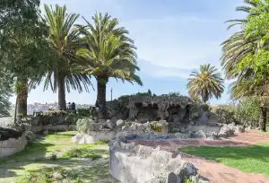 Palm-lined park with rocky grotto and panoramic view of Porto's historic centre