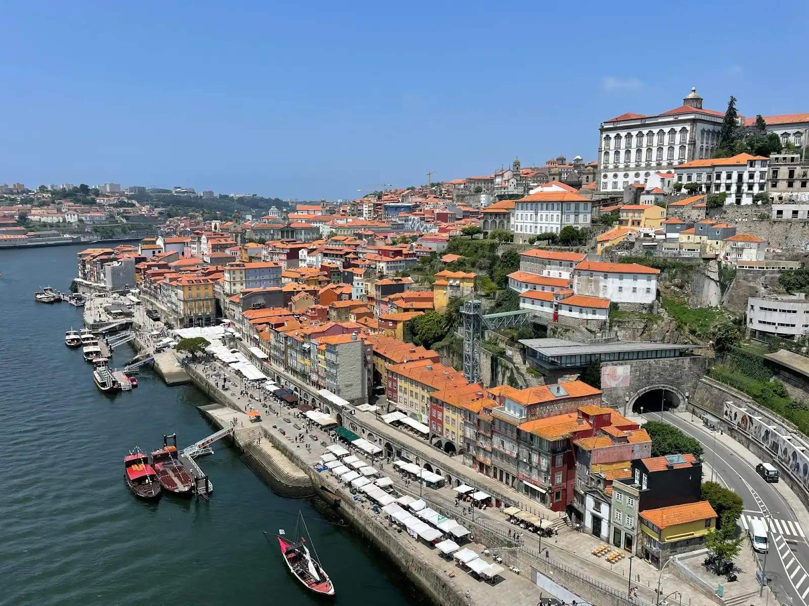 Ribeira waterfront and hillside buildings along the Douro River in Porto with rabelo boats moored