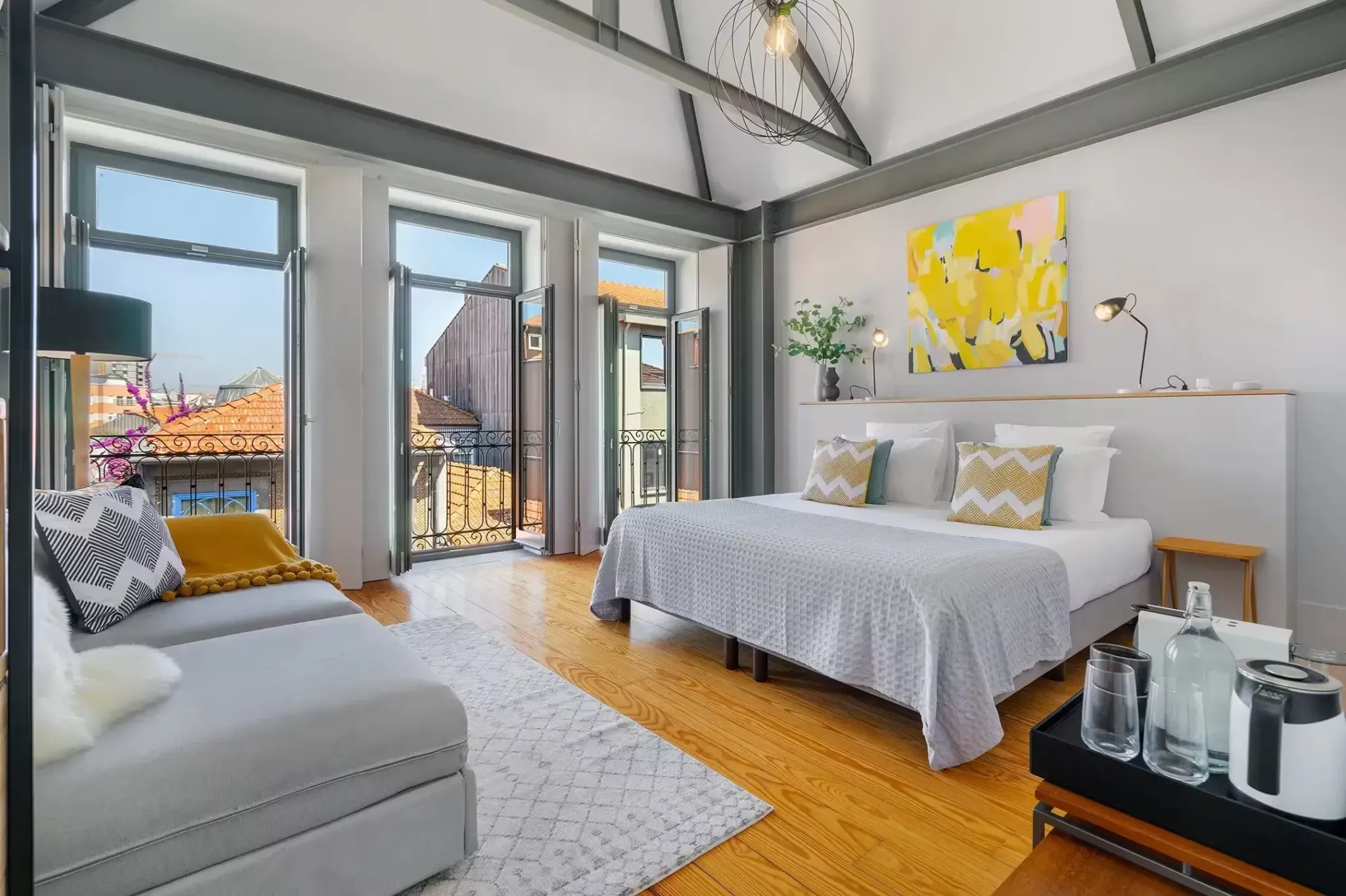 Canto de Luz Maison suite in Porto with exposed steel beams and balcony doors opening over the rooftops